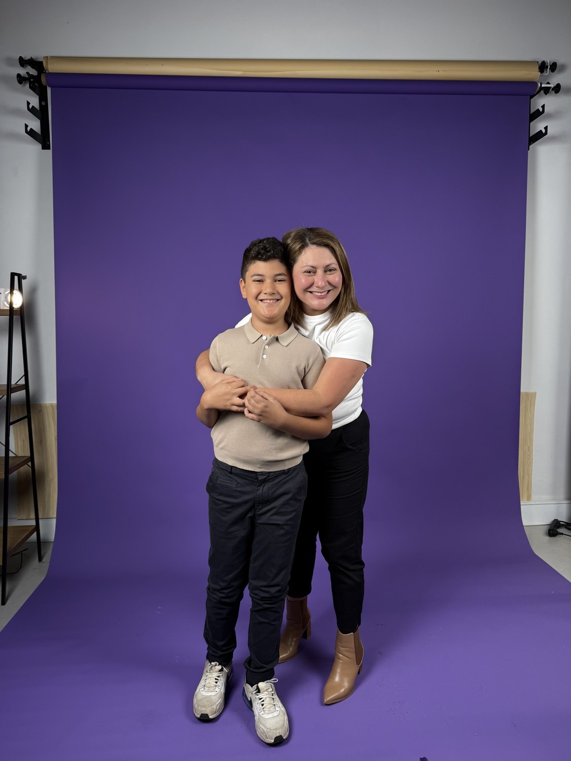 Jessica hugging her son on a purple studio backdrop