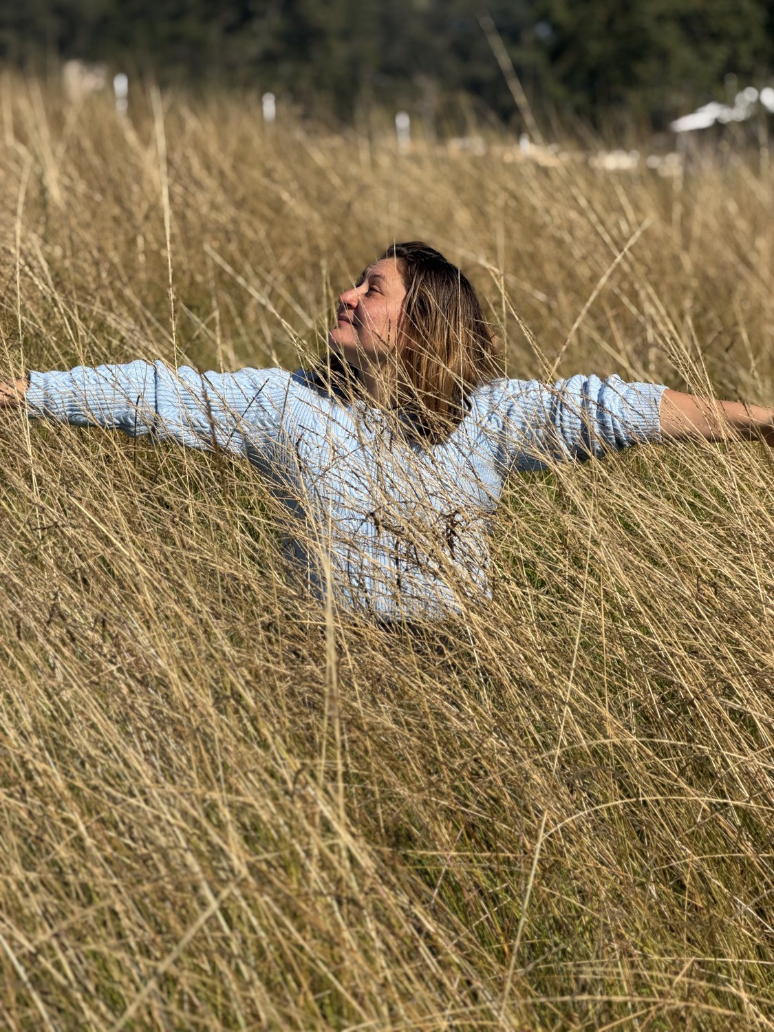 Jessica in tall grass, arms open, natural look