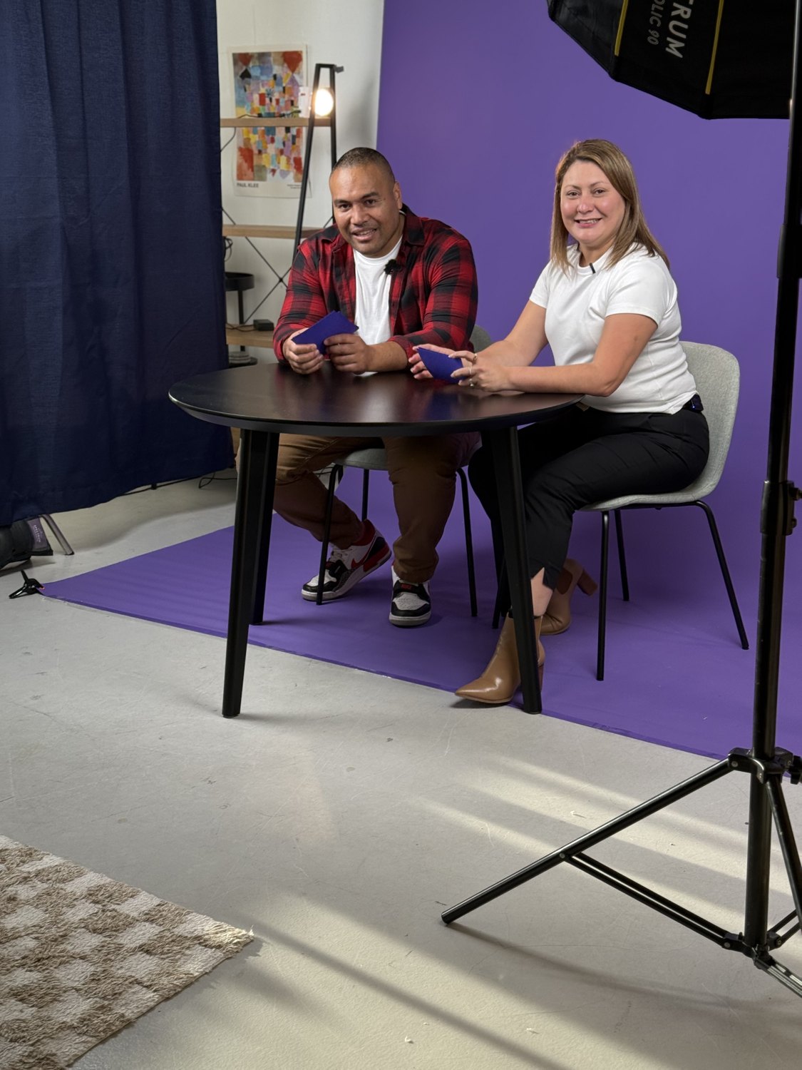 Jessica co-hosting a podcast in a purple studio